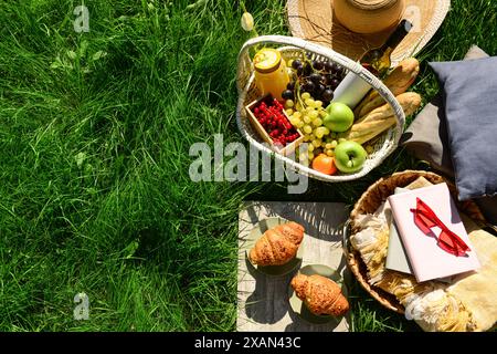 Das Hotel bietet ein romantisches Picknick mit Korb voller leckerer Speisen und Getränke auf dem Gras im Park Stockfoto