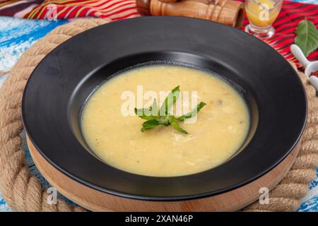 Fischsuppe in einer Schüssel. Fischsuppe mit Sahne, Soßen, Zitrone, Kräutern und Croutons auf hölzernem Hintergrund. Stockfoto