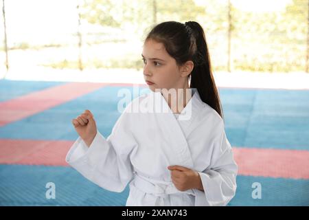 Ein Mädchen in Kimono, das draußen Karate auf Tatami übt Stockfoto