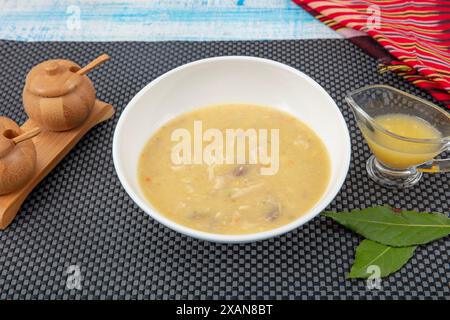 Fischsuppe in einer Schüssel. Fischsuppe mit Sahne, Soßen, Zitrone, Kräutern und Croutons auf hölzernem Hintergrund. Stockfoto