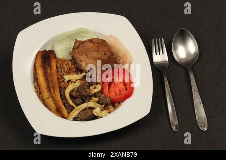 Blick von oben auf einen Teller mit köstlichem Nasi-Goreng, gebratenem Krupuk-Kochbananen, Ei, Tomatenscheiben und Hühnerleber-Sambal. Stockfoto