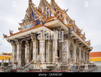 Ein Eingang und ein Seitenblick auf den Wat Pariwat Tempel. Der Tempel Wat Pariwat Ratchasongkram, auch bekannt als David Beckham Tempel wegen seiner Statue des berühmten Fußballstars, ist ein einzigartiger und unkonventioneller buddhistischer Tempel mit dem Konzept, moderne Kunst und Kultur in das Design des Tempels zu integrieren, um jüngere Generationen anzuziehen und den Buddhismus besser zu verbinden die heutige Gesellschaft. Trotz seiner unkonventionellen Erscheinung mit farbenfrohen Wandgemälden von Superhelden und Zeichentrickfiguren ist Wat Pariwat ein verehrter Ort für Buddhisten und ein beliebter Ort für Touristen, die eine einzigartige kultur suchen Stockfoto