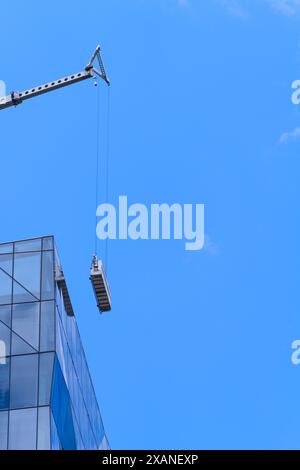 Kranabsenkende Reinigungsfenster Ausrüstung auf Hochhäusern, mit blauem Himmel Hintergrund, Melbourne Australien. Stockfoto