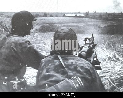 Screenshot des Zweiten Weltkriegs in Schwarzweiß. Deutsche Maschinenschützer greifen russische Truppen im Juli 1941 an der Russischen Front an . Die Besatzung ist von der 3. SS Totenkopf Division Stockfoto