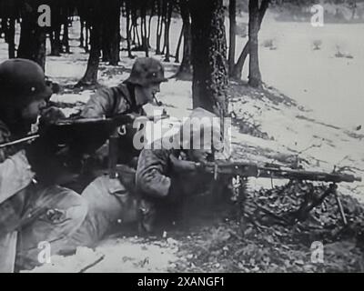 Screenshot des Zweiten Weltkriegs in Schwarzweiß. Waffen-SS-Männer der Wiking-Division nehmen mit MG am Rande eines bewaldeten Gebiets in Ungarn im Februar 1945 Stellung Stockfoto