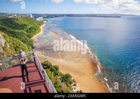 Zwei Personen (MR) auf der Aussichtsebene am Two Lovers Point oder Puntan Dos Amantes, mit Tumon Bay im Hintergrund, Guam, Mikronesien, Mariana Island Stockfoto