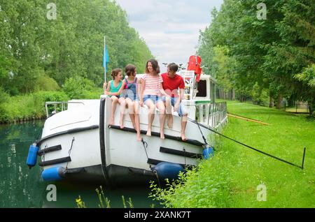 Familienurlaub, Sommerurlaub auf dem Binnenschiff im Kanal, glückliche Kinder und Eltern, die Spaß auf einer Flussfahrt im Hausboot in Frankreich haben Stockfoto