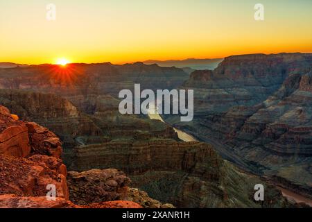 Aussichtspunkt Blick auf die Klippen des Grand Canyon mit komplexen Schichten, die durch das Sonnenlicht hervorgehoben werden, mit einem sich windenden Fluss am Fuß, der einige davon reflektiert Stockfoto