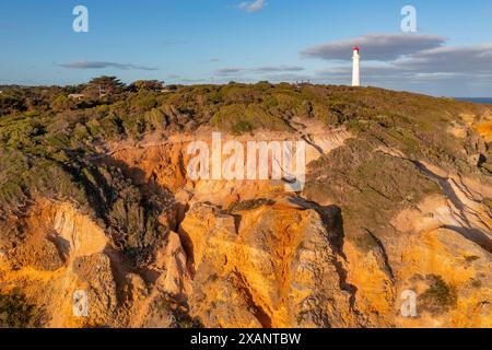 Blick aus der Vogelperspektive auf einen weißen Leuchtturm auf zerklüfteten, erodierten Klippen am Aireys Inlet an der Great Ocean Road in Victoria, Australien Stockfoto