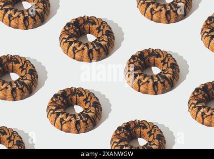 Kreatives trendiges Lebensmittelmuster aus köstlichem Kuchen mit Schokoladenbelag auf weißem Hintergrund. Minimales süßes Dessertkonzept. Tortenästhetik. Stockfoto