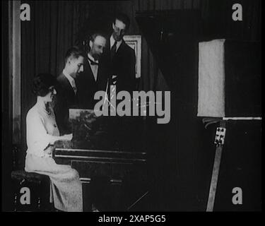 Radio-Darsteller spielen Musik und singen, 1922. Aus "Time to Remember - Sitting still and going Slow", 1922 (Reel 4); ein Überblick über die Ereignisse im Jahr 1922 einschließlich irischer Probleme, Krieg zwischen Griechenland und der Türkei und Entwicklungen in der Luftfahrt und im Radio. Stockfoto