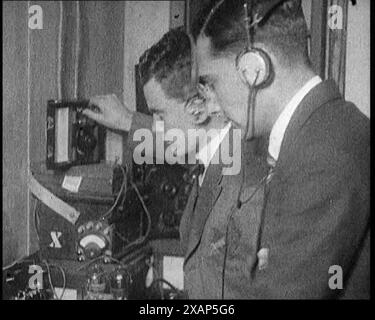 Zwei Männer, die Kopfhörer tragen und drahtlose Geräte kalibrieren, 1922. Aus "Time to Remember - Sitting still and going Slow", 1922 (Reel 4); ein Überblick über die Ereignisse im Jahr 1922 einschließlich irischer Probleme, Krieg zwischen Griechenland und der Türkei und Entwicklungen in der Luftfahrt und im Radio. Stockfoto