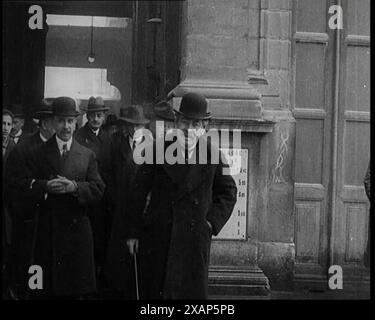 Der französische Premierminister Aristide Briand stand draußen mit einer Gruppe männlicher Zivilisten in Hüten, 1926. "So instabil Deutschland auch schien, die anderen westlichen Nationen hielten es für angebracht, sie in den Völkerbund aufzunehmen. "Besser rein als raus", sagten viele. Traditionelle Gegner Deutschlands wie Frankreich behielten ihre wahren Gedanken für sich, aber sie ließen sie trotzdem rein. Aus „Time to Remember 1926 – Short Sharp Shower“ – Reel 1; ein Dokumentarfilm über 1926 – General Strike, internationale Politik, Tanz, Wetter und rekordbrechende Meisterleistungen. Stockfoto