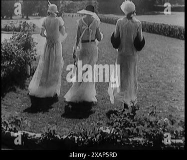 Eine Gruppe von drei weiblichen Zivilisten in modischer Kleidung, stehend in einem Garten, 1929. „Sie sagen mir, dass viele der Mode dieser Zeit wieder da sind“. Aus „Time to Remember – 1929 The Time of the House at Bognor“ – Reel 1; ein Dokumentarfilm über die Welt im Jahr 1929. Krankheit von König Georg V. &amp; wirtschaftliche Depression. Stockfoto