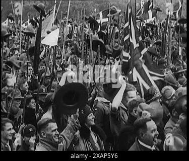 Viele Pfadfinder und männliche Zivilisten jubeln Jamboree an, 1929. Internationales Pfadfindertreffen in Großbritannien. Aus „Time to Remember – 1929 The Time of the House at Bognor“ – Reel 2; ein Dokumentarfilm über die Welt im Jahr 1929. Krankheit von König Georg V. &amp; wirtschaftliche Depression. Stockfoto