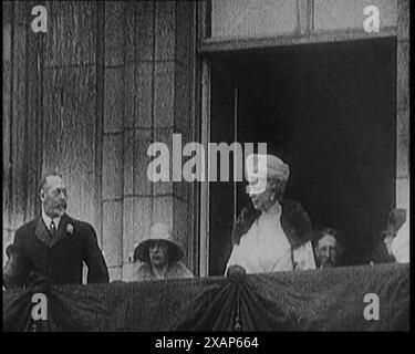 König Georg V. und Königin Maria von Teck und andere Mitglieder der königlichen Familie stehen auf dem Balkon des Buckingham Palace, 1929. „König Georg V. war [nach einer Krankheit] zurück, und als er und Königin Mary zum Buckingham Palace fuhren, sah Großbritannien das Ereignis als etwas, von dem man Kraft schöpfen konnte“. Der König hatte drei Monate in Bognor verbracht, um sich zu erholen, und im selben Jahr wurde der Name der Stadt durch königliche Zustimmung in „Bognor Regis“ geändert. Aus „Time to Remember – 1929 The Time of the House at Bognor“ – Reel 4; ein Dokumentarfilm über die Welt im Jahr 1929. Krankheit von König George V&amp; Wirtschaftsabteilung Stockfoto