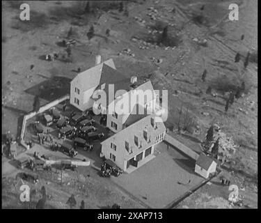 Luftaufnahme des Hauses des amerikanischen Piloten Charles Augustus Lindbergh während einer Entführungsuntersuchung, 1930er Jahre Der Fall von Lindbergh-Baby-Entführung von 1932 - "das Verbrechen des Jahrhunderts". „Ein offenes Fenster, eine Leiter, und der Lindbergh-Junge ist weg... eine der größten und umfangreichsten Suchen der Geschichte durchkämmt die Gegend um das Lindbergh-Haus [in New Jersey]... Ein einfaches Holzhaus wird zum Zentrum der Welt...“ Aus „Time to Remember – The Tough Guys“, 1930er Jahre (Reel 2); Dokumentarfilm, hauptsächlich über das Leben in Amerika mit Depressionen und Gangstern. Stockfoto