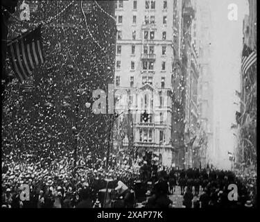 Große Menschenmenge mit amerikanischer Flagge im Vordergrund, 1933. "Am Broadway erhalten General Balbo und sein Pilotenteam den Empfang, auf den diese Straße spezialisiert ist." Aus „Time to Remember – The Time of the Monster“, 1933 (Reel 2); Dokumentarfilm über die Ereignisse von 1933, Rise of Roosevelt and Hitler. Stockfoto