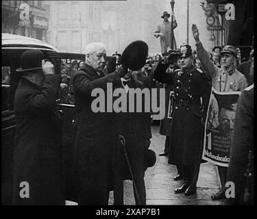 Bundespräsident Paul von Hindenburg grüßt eine Menschenmenge, 1933. „Obwohl er der [nationalsozialistischen] Partei verdächtig war, hat sich der alte Präsident Hindenburg dafür entschieden, sie als das geringste Übel zu unterstützen“. Beachten Sie das Poster von Hindenburg und seinem Kanzler Adolf Hitler rechts. Aus „Time to Remember – The Time of the Monster“, 1933 (Reel 2); Dokumentarfilm über die Ereignisse von 1933, Rise of Roosevelt and Hitler. Stockfoto