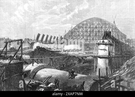 Werke des Midland Railway Terminus, Euston-Road, 1868. Bau des neuen Bahnhofs St. Pancras in London. Half Somers Town wurde abgerissen... der Metropolitan Tunnel der Midland Railway wird ein wichtiges Verkehrsmittel sein, da er Passagiere, die von Derby oder Manchester ankommen, direkt in das Herz der Stadt bringen wird...[die Ansicht zeigt] Ziegelsteinmauern, die den Tunnel im Vordergrund bedecken,... King's Cross nach rechts, und das Brill... auf der linken Seite, mit dem Kirchturm von Oakley-Square in der Ferne. Die enorme Spannweite der Eisenbögen, die das Dach des Bahnhofs bilden... füllt h aus Stockfoto