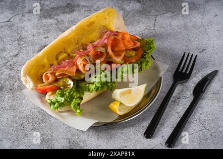 Sandwich mit geräuchertem Lachs auf Metallteller auf Steintisch Stockfoto