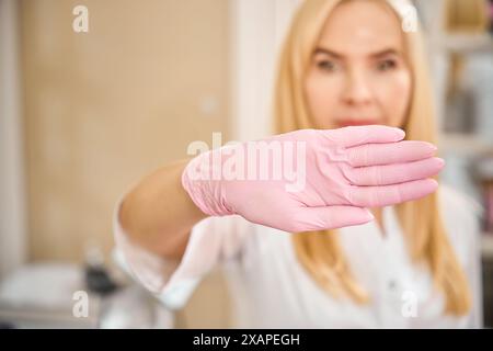 Ärztin demonstriert Stop-Geste vor der Kamera in ihrer Praxis Stockfoto