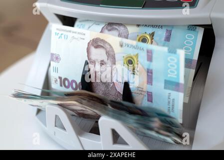 Zählgerät für Banknoten. Ukrainisches Geld in einer Rechenmaschine. Ukrainisches Geld wird von einem Automaten für Banknoten gezählt. Ukrainische Hrywna. Stockfoto