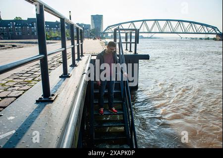 Ein Mann wird gesehen, wie er auf das Hochwasser im Fluss blickt. Der anhaltende Regen in Süddeutschland führt zu einem Anstieg der Wasserstände in den Niederlanden nahe Deutschland. d. in der Grenzstadt Lobith an Gelderland wurde ein Wasserstand von 12,85 Metern über dem NAP (der Basis zur Messung der Wasserstände) gemessen. In Nijmegen befinden sich niedrige Teile des Kais und rund um den Hafen an der Waalkade unter Wasser. Der Wasserstand des Rheins erreichte am Freitagmorgen einen Höchststand, war aber weniger hoch als ursprünglich erwartet. Es wurde erwartet, dass das Wasser mehr als 13 Meter über dem NAP steigen würde. (Foto von Ana Fernand Stockfoto