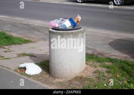 Öffentliche Mülltonnen auf einer Stadtstraße voller Müll Stockfoto