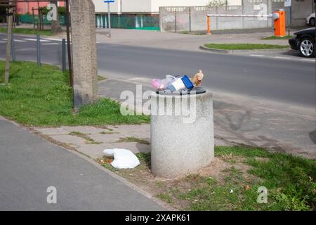 Öffentliche Mülltonnen auf einer Stadtstraße voller Müll Stockfoto