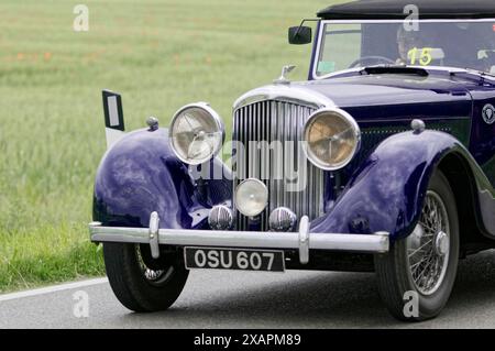 Blauer Oldtimer auf Landstraße mit grüner Landschaft im Hintergrund, Oldtimer, Autorennen, Mille Miglia, 1000 Miglia, Toskana, Rom, Gardasee Stockfoto