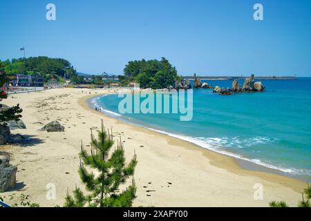 Donghae City, Südkorea - 18. Mai 2024: Ein malerischer Blick auf Chuam Beach mit dem berühmten Chuam Candlestick Rock, mit Strandgängern, die den Ccle genießen Stockfoto