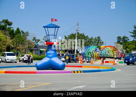 Donghae City, Südkorea - 18. Mai 2024: Der farbenfrohe und einladende Eingang zum Chuam Beach zeigt eine verspielte Leuchtturmskulptur und ein lebhaftes rai Stockfoto