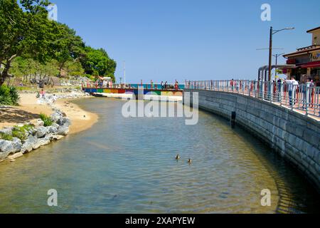 Donghae City, Südkorea - 18. Mai 2024: Ein ruhiger Fluss fließt in Richtung Chuam Beach, mit einer bunten Brücke und einer malerischen Umgebung, die eine se bietet Stockfoto