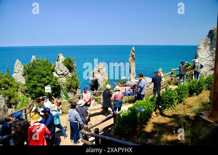 Donghae City, Südkorea - 18. Mai 2024: Touristen versammeln sich, um den berühmten Chuam Candlestick Rock entlang der Ostseeküste zu sehen und zu fotografieren. Stockfoto