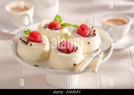 Leckerer Käsekuchen Monoportion mit Beeren und Vanille. Erdbeer-Käsekuchen mit Vanille glasiert. Stockfoto