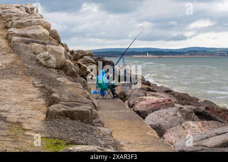 Milford on Sea, Hampshire, Großbritannien. Juni 2024. Wetter in Großbritannien: Sonnige Intervalle in Milford-on-Sea, Hampshire, Großbritannien. Ein Mann macht einen Angelplatz. Quelle: Carolyn Jenkins/Alamy Live News Stockfoto