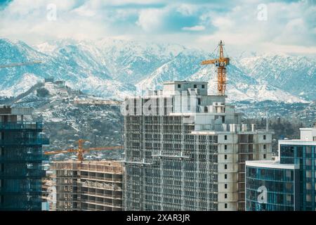 Baukran ist an der Entwicklung Eines neuen mehrstöckigen Wohngebäudes beteiligt. Neue mehrstöckige Wohnhäuser am Blue Sky. Immobilien Stockfoto