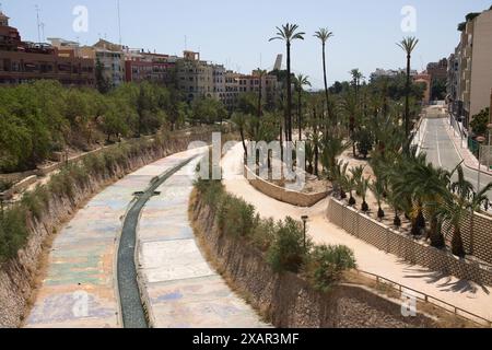 Blick von einer Brücke über den Fluss Vinalopo, in der Stadt Elche (Alicante, Spanien) mit einem eingezäunten und gekannten Kanal, der renaturiert werden muss Stockfoto