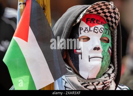 Maskierter Pro-Palästina-Unterstützer. Palästina Gaza-Krieg Proteste in Manchester Großbritannien. Demonstranten marschierten vom St Peter's Square zur Manchester University, wo Studenten das Whitworth-Gebäude besetzten und ein Zeltlager auf dem Campus der University of Manchester aufbauten, um gegen die Kontakte der Universität mit Israel zu protestieren. Auf den Bannern wurden Nachrichten geschrieben, in denen Großbritannien aufgefordert wurde, Israel nicht mehr zu bewaffnen, und die Wähler, bei den bevorstehenden Wahlen im Vereinigten Königreich nicht für Rishi Sunak und Keir Starmer zu stimmen. Manchester UK>Bild: Garyroberts/worldwidefeatures.com Stockfoto