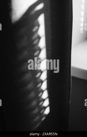 Schatten der Strahlen, die durch Vorhänge auf die Wand fallen. Abstrakter Schatten und gestreifter diagonaler Lichthintergrund vom Fenster, Hintergrund und Modell Stockfoto