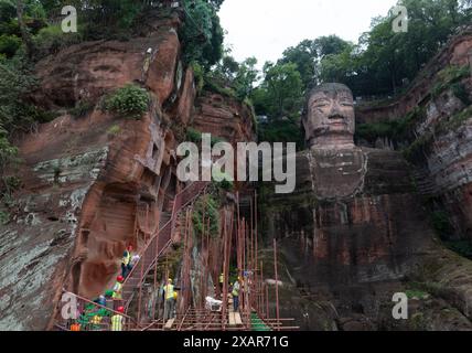 (240608) -- LESHAN, 8. Juni 2024 (Xinhua) -- dieses Drohnenfoto zeigt Arbeiter, die einen Hügel um den Leshan RiesenBuddha in der südwestlichen Provinz Sichuan verstärken, 4. Juni 2024. Der im 8. Jahrhundert aus einem Hügel gemeißelte Leshan Riesen Buddha ist ein Gebiet von natürlicher Schönheit, in das das menschliche Element mit Geschick und Subtilität integriert wurde. Gegenüber dem Zusammenfluss der Flüsse Minjiang, Dadu und Qingyi ist der 71 Meter hohe RiesenBuddha von Leshan einer der wichtigsten kulturellen Schätze Chinas. Der Leshan-RiesenBuddha wurde in die Liste des UNESCO-Weltkulturerbes aufgenommen Stockfoto