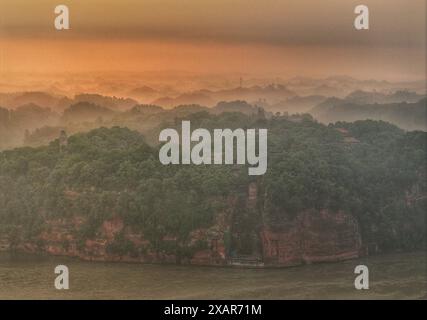 (240608) -- LESHAN, 8. Juni 2024 (Xinhua) -- dieses Luftdrohnenfoto zeigt den Leshan-RiesenBuddha bei Sonnenaufgang in der südwestlichen Provinz Sichuan, 4. Juni 2024. Der im 8. Jahrhundert aus einem Hügel gemeißelte Leshan Riesen Buddha ist ein Gebiet von natürlicher Schönheit, in das das menschliche Element mit Geschick und Subtilität integriert wurde. Gegenüber dem Zusammenfluss der Flüsse Minjiang, Dadu und Qingyi ist der 71 Meter hohe RiesenBuddha von Leshan einer der wichtigsten kulturellen Schätze Chinas. Der Leshan Giant Buddha wurde 1996 in die Liste des UNESCO-Weltkulturerbes aufgenommen. (Xinhua/Jiang Stockfoto