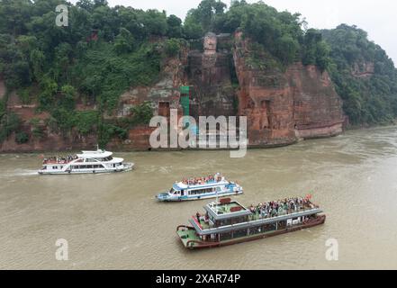 (240608) -- LESHAN, 8. Juni 2024 (Xinhua) -- dieses Drohnenfoto zeigt Touristen auf Booten, die den Leshan RiesenBuddha in der südwestlichen Provinz Sichuan besuchen, 4. Juni 2024. Der im 8. Jahrhundert aus einem Hügel gemeißelte Leshan Riesen Buddha ist ein Gebiet von natürlicher Schönheit, in das das menschliche Element mit Geschick und Subtilität integriert wurde. Gegenüber dem Zusammenfluss der Flüsse Minjiang, Dadu und Qingyi ist der 71 Meter hohe RiesenBuddha von Leshan einer der wichtigsten kulturellen Schätze Chinas. Der Leshan Giant Buddha wurde 1996 in die Liste des UNESCO-Weltkulturerbes aufgenommen. (X Stockfoto