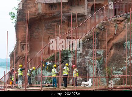 (240608) -- LESHAN, 8. Juni 2024 (Xinhua) -- dieses Drohnenfoto zeigt Arbeiter, die einen Hügel um den Leshan RiesenBuddha in der südwestlichen Provinz Sichuan verstärken, 4. Juni 2024. Der im 8. Jahrhundert aus einem Hügel gemeißelte Leshan Riesen Buddha ist ein Gebiet von natürlicher Schönheit, in das das menschliche Element mit Geschick und Subtilität integriert wurde. Gegenüber dem Zusammenfluss der Flüsse Minjiang, Dadu und Qingyi ist der 71 Meter hohe RiesenBuddha von Leshan einer der wichtigsten kulturellen Schätze Chinas. Der Leshan-RiesenBuddha wurde in die Liste des UNESCO-Weltkulturerbes aufgenommen Stockfoto