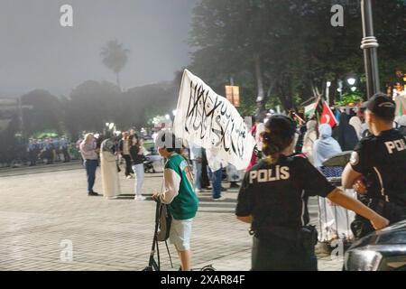 Junge auf einem Roller mit der Flagge des Islamischen Staates, der während propalästinensischer Proteste vor der Hagia-Sophia-Moschee in Istanb an der türkischen Polizei vorbeifährt Stockfoto