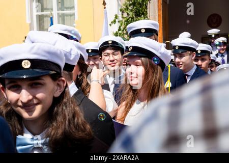 SCHÜLER, DIE DIE SCHULE ZUM LETZTEN MAL VERLASSEN, CELEBRATION, Åland, FINNLAND: Die neuen Absolventen kommen zum letzten Mal aus ihrer Schule, um einen ausgelassenen Empfang von Freunden und Familien zu feiern, die sich vor dem Hauptschulgebäude zum Åland-Abschlussfeiertag 2024 im Åland Lyceum (Ålands Gymnasium) in Mariehamn, Åland Archipel, versammelt haben. Ostsee, Finnland – an diesem Tag verlassen die Schüler die Schule zum letzten Mal. Im Rahmen dieser nordischen Tradition werden Plakate mit Babybildern der Absolventen aufgehalten und die Studenten tragen ihre Studentmössa im Matrosenstil. Stockfoto