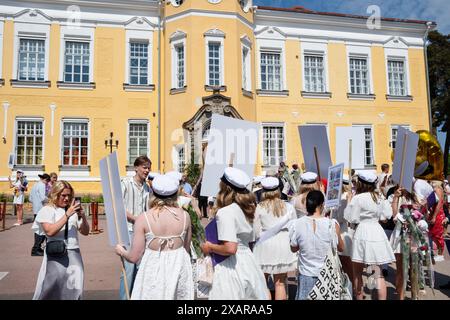 MÄDCHEN POSIEREN FÜR GRUPPENFOTO, Åland GRADUATION, MARIEHAMN: Eine große Gruppe von Mädchen, die Absolventen sind, posieren für ein festliches Bild mit Blumen und ihren Babyplakaten vor dem Hauptschulgebäude am Åland Graduierungstag 2024 im Åland Lyceum (Ålands Gymnasium) in Mariehamn, Åland Archipel, Ostsee, Finnland – an diesem Tag verlassen die Schüler die Schule zum letzten Mal. Im Rahmen dieser nordischen Tradition werden Plakate mit Babybildern der Absolventen aufgehalten, und die Studenten tragen ihre Studentmössa im Matrosenstil und kleiden sich in Anzügen und weißen Kleidern. Stockfoto