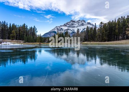 Johnson Lake gefrorene Wasseroberfläche im Winter. Schneebedeckter Cascade Mountain im Hintergrund. Banff National Park, Kanadische Rockies, Alberta, Kanada. Stockfoto