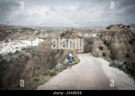 Einsamer Läufer im Regen, Aufstieg zum Aussichtspunkt Fin Del Mundo, Beas de Guadix, Granada Geopark, Granada Provinz, Andalusien, Spanien. Stockfoto